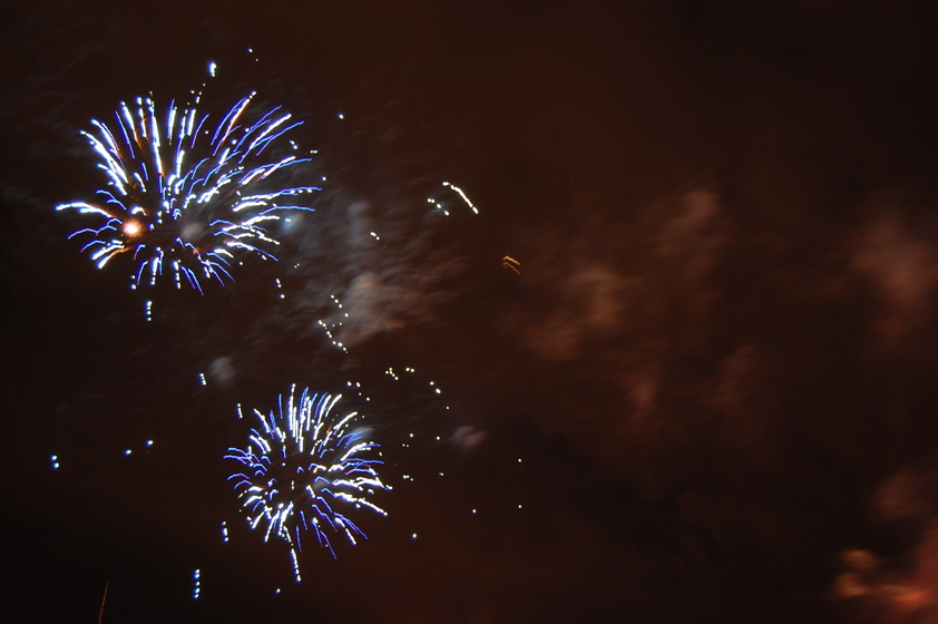 Fireworks light up the night sky in a dazzling display of blue color and light.