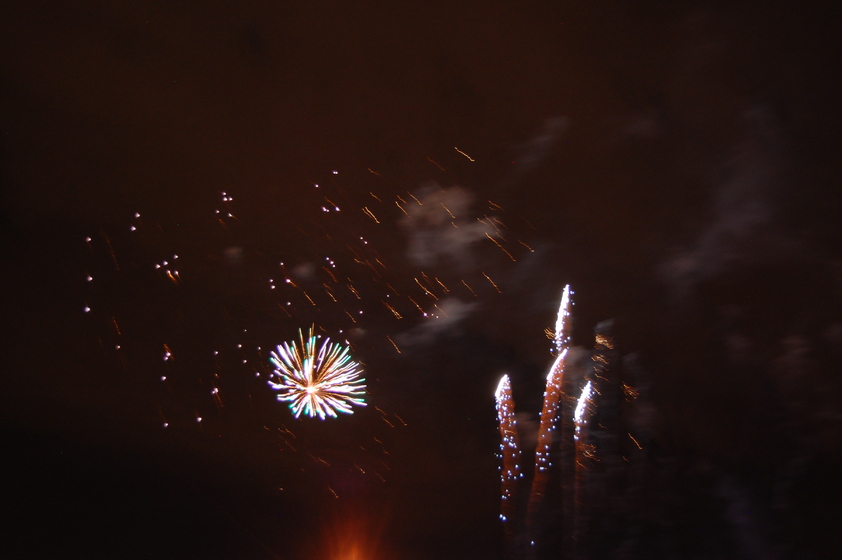 Bright bursts of red, green, gold, and blue light fill the dark night sky.