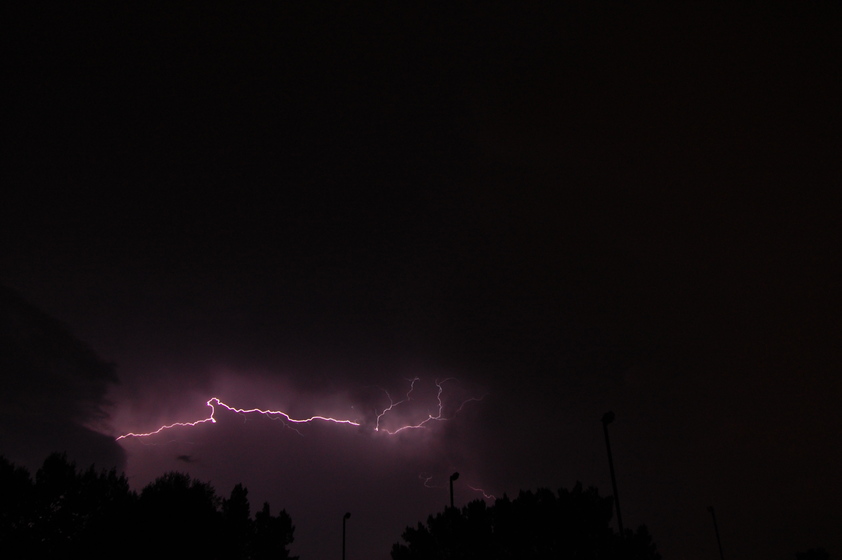 A bright, jagged lightning bolt illuminates the dark night sky.