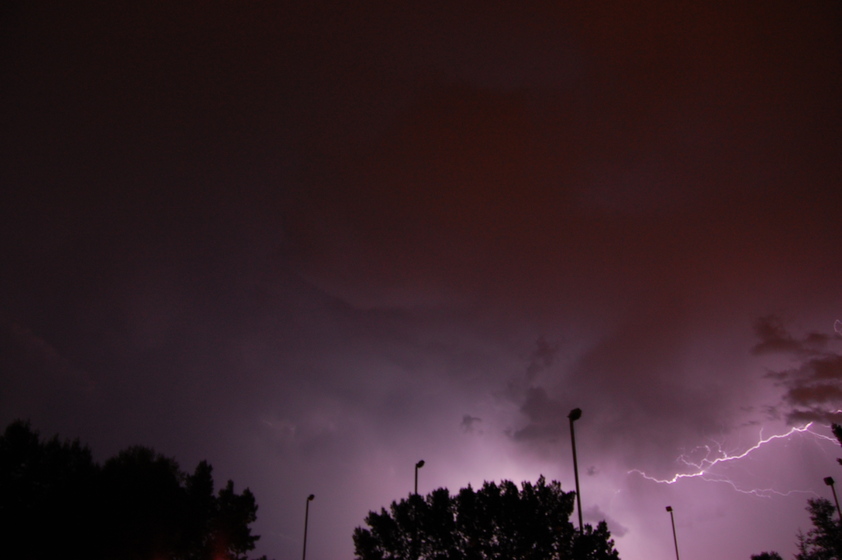 Jagged lightning streaks across the sky during a thunderstorm at night.