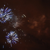 Fireworks light up the night sky in a dazzling display of blue color and light.