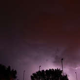Jagged lightning streaks across the sky during a thunderstorm at night.